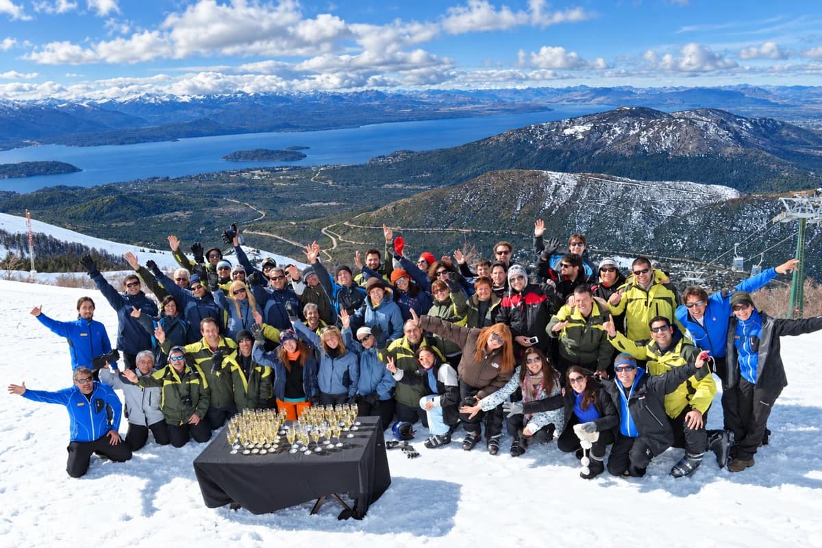 Grupo de trabalho com roupa de neve, reunido na montanha em um dia de céu limpo