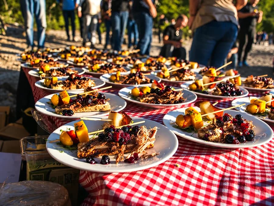 Mesa montada al aire libre con platos servidos para un grupo, sobre mantel a cuadros