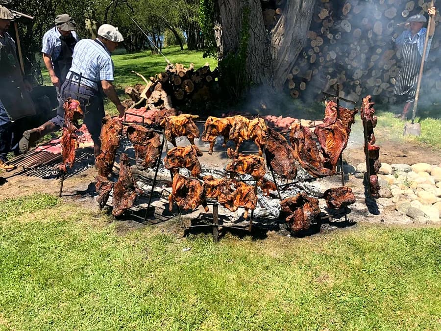 Asado criollo al palo, con corderos alrededor del fuego