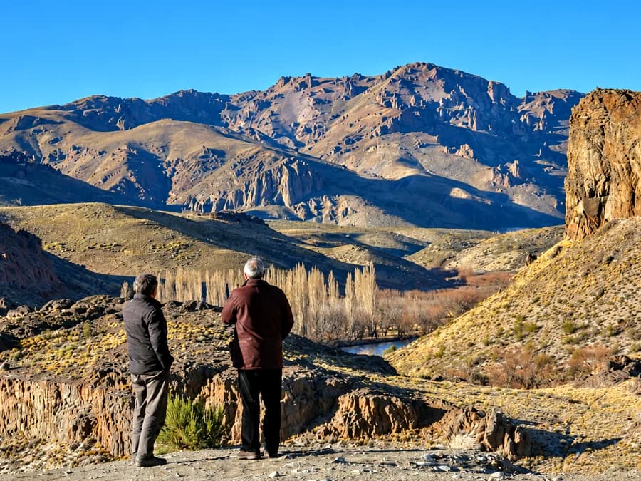 Dos personas mirando el cañadón desde un mirador de la estepa