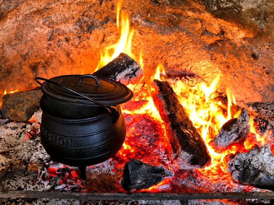 Olla de hierro sobre las brasas de un fuego a leña